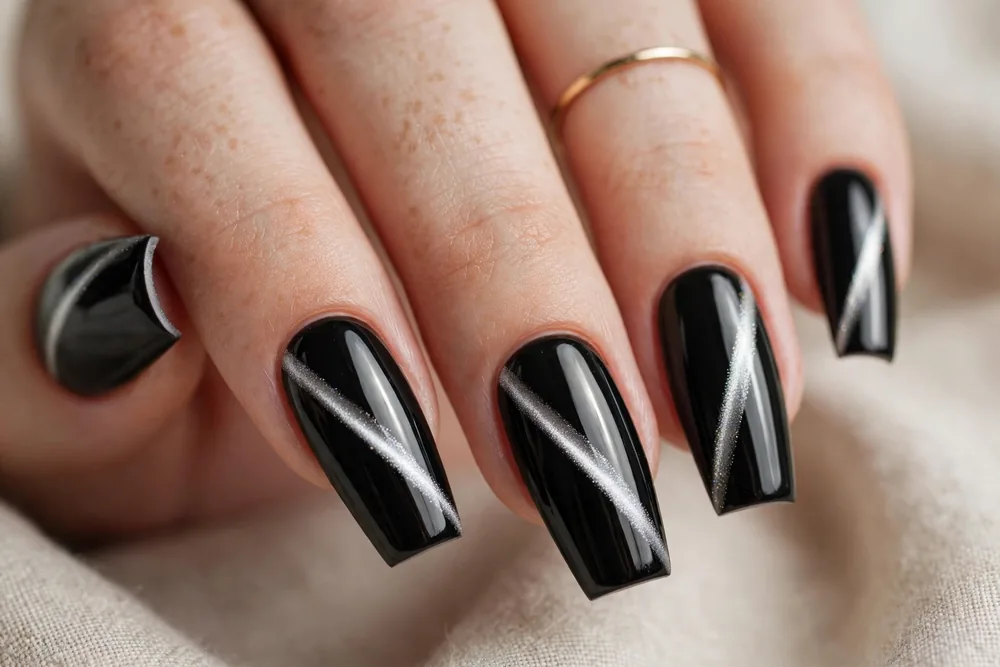 Black cat eye nails with crisp silver line on medium coffin nails