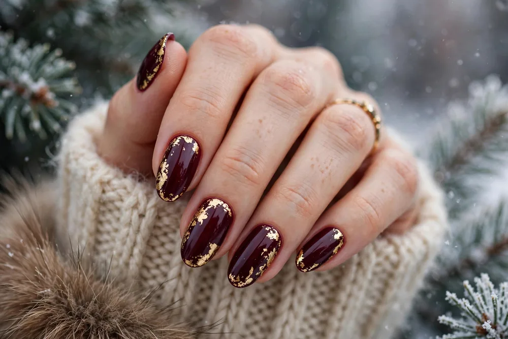 Deep burgundy winter nails with gold leaf
